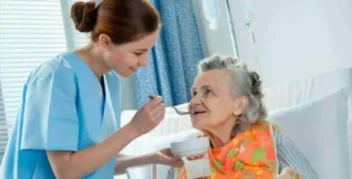 blog lar sitio da luz. Cuidadora alimentando idosa com carinho para garantir alimentação adequada